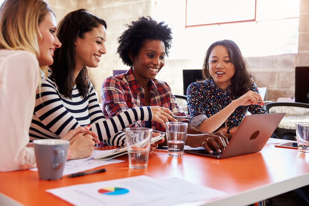 Female consultants talking around a table.
