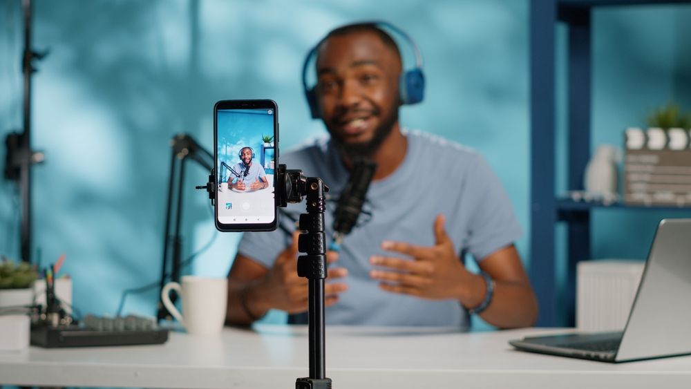 A content creator filming themselves and speaking into a microphone.